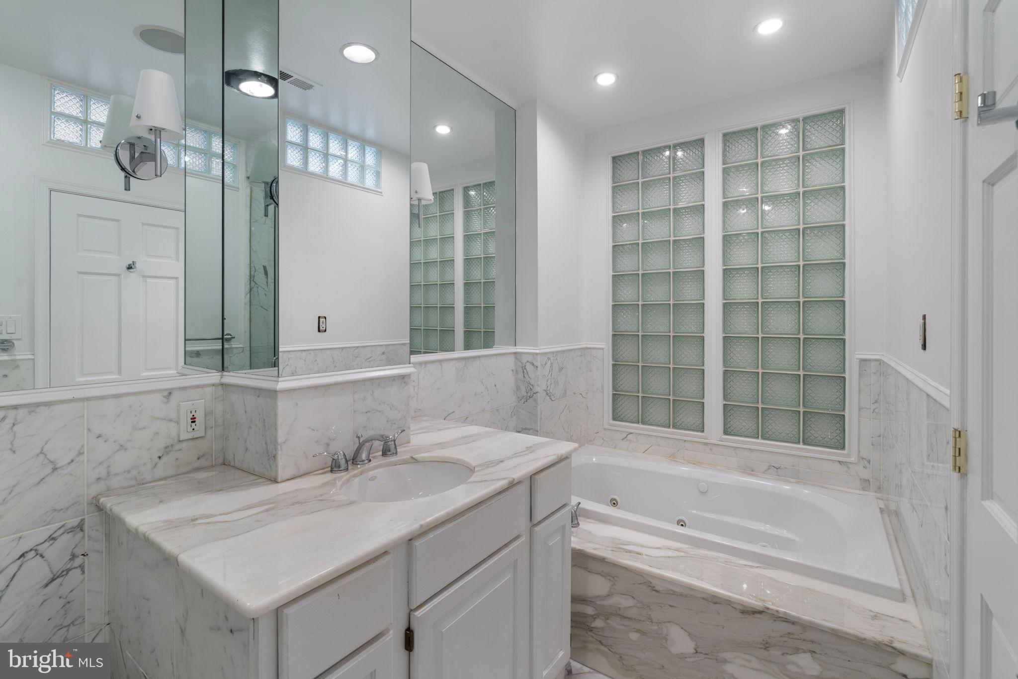 2036 Rittenhouse Square Philadelphia, PA 19103 - Photo 36 of 39 a bathroom with a sink double vanity granite tub shower and a mirror