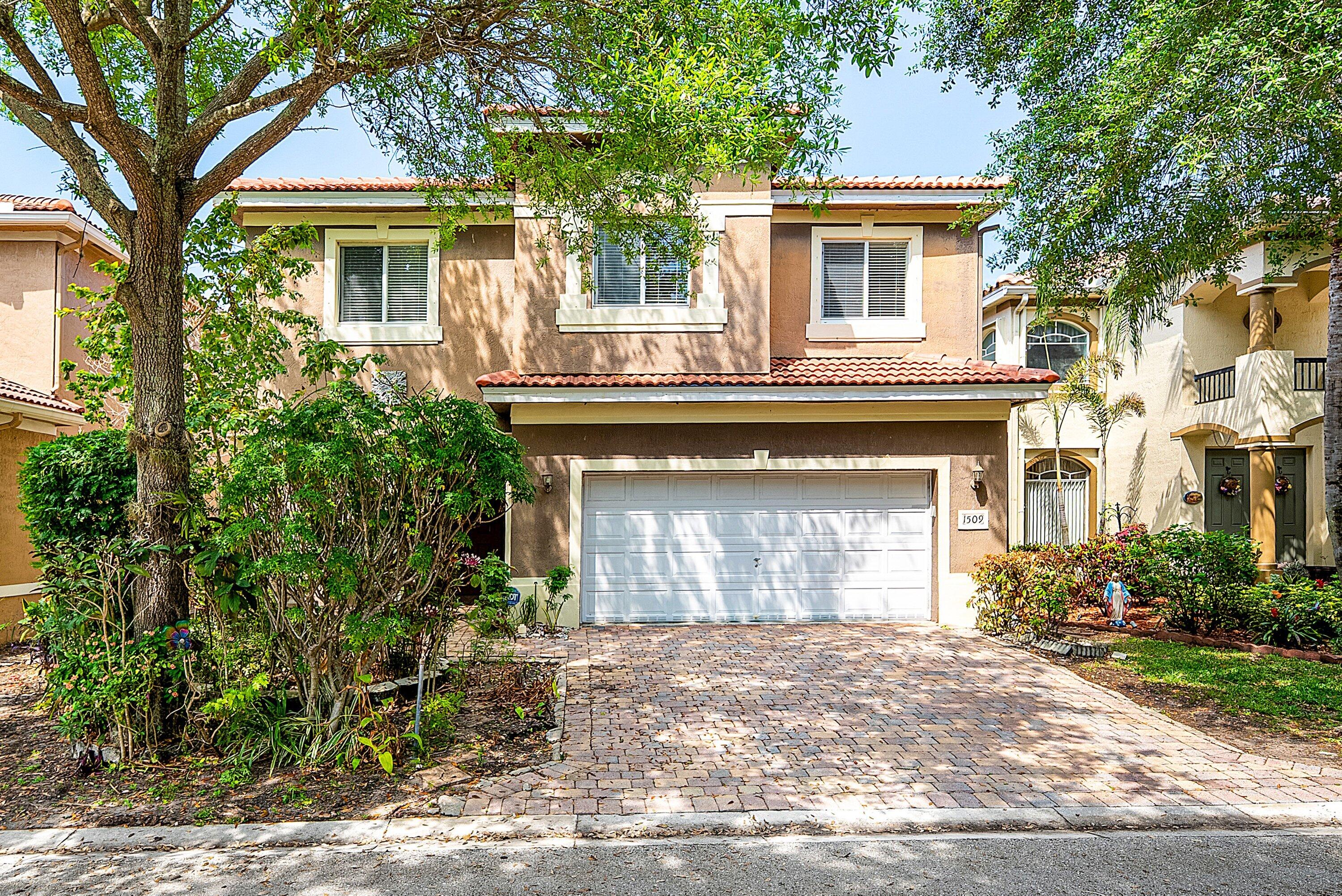1509 Sage Wood Court Riviera Beach, FL 33404 - Photo 1 of 59 a front view of a house with a yard and a garage
