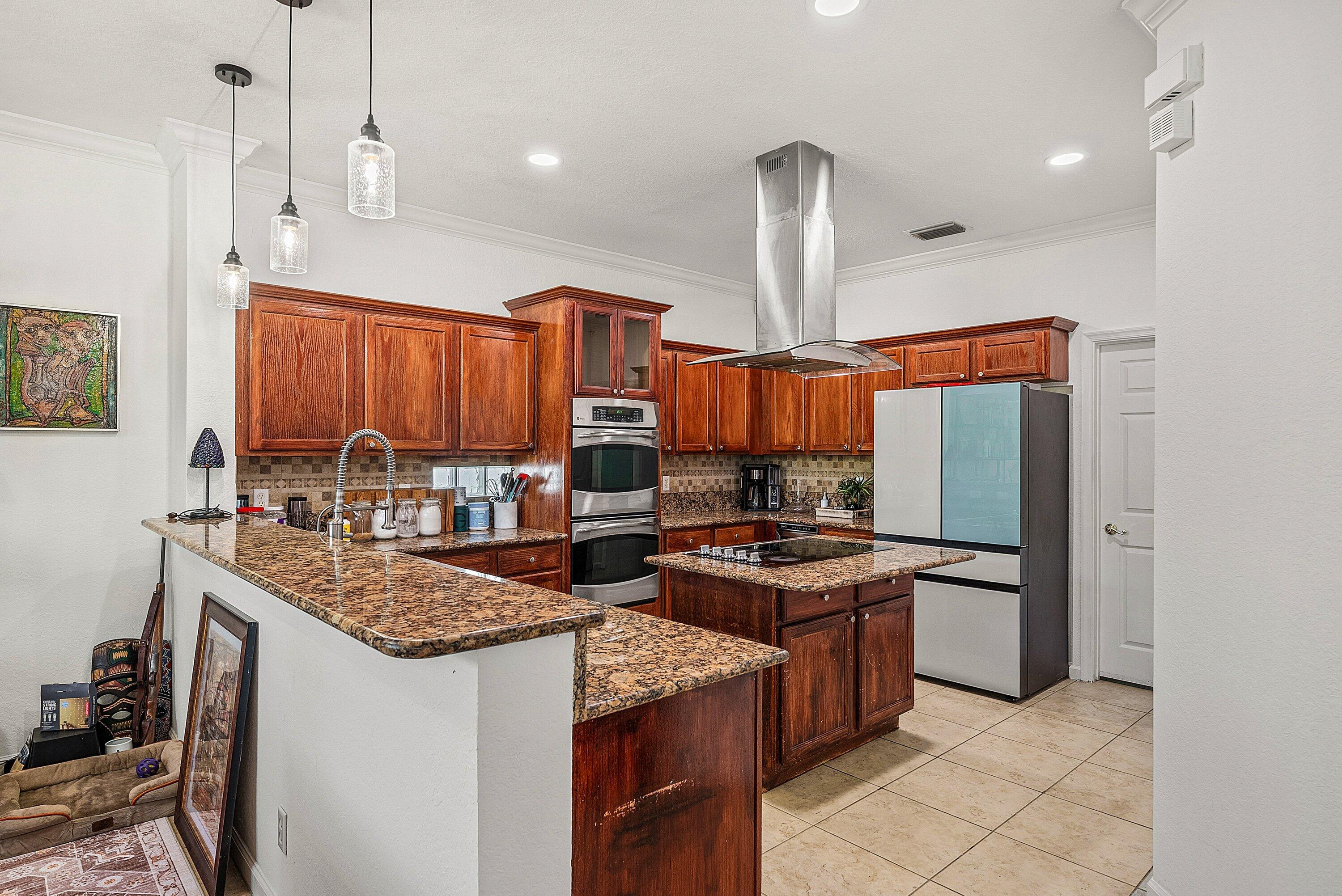 1509 Sage Wood Court Riviera Beach, FL 33404 - Photo 16 of 59 a kitchen with stainless steel appliances granite countertop a stove a sink and a refrigerator