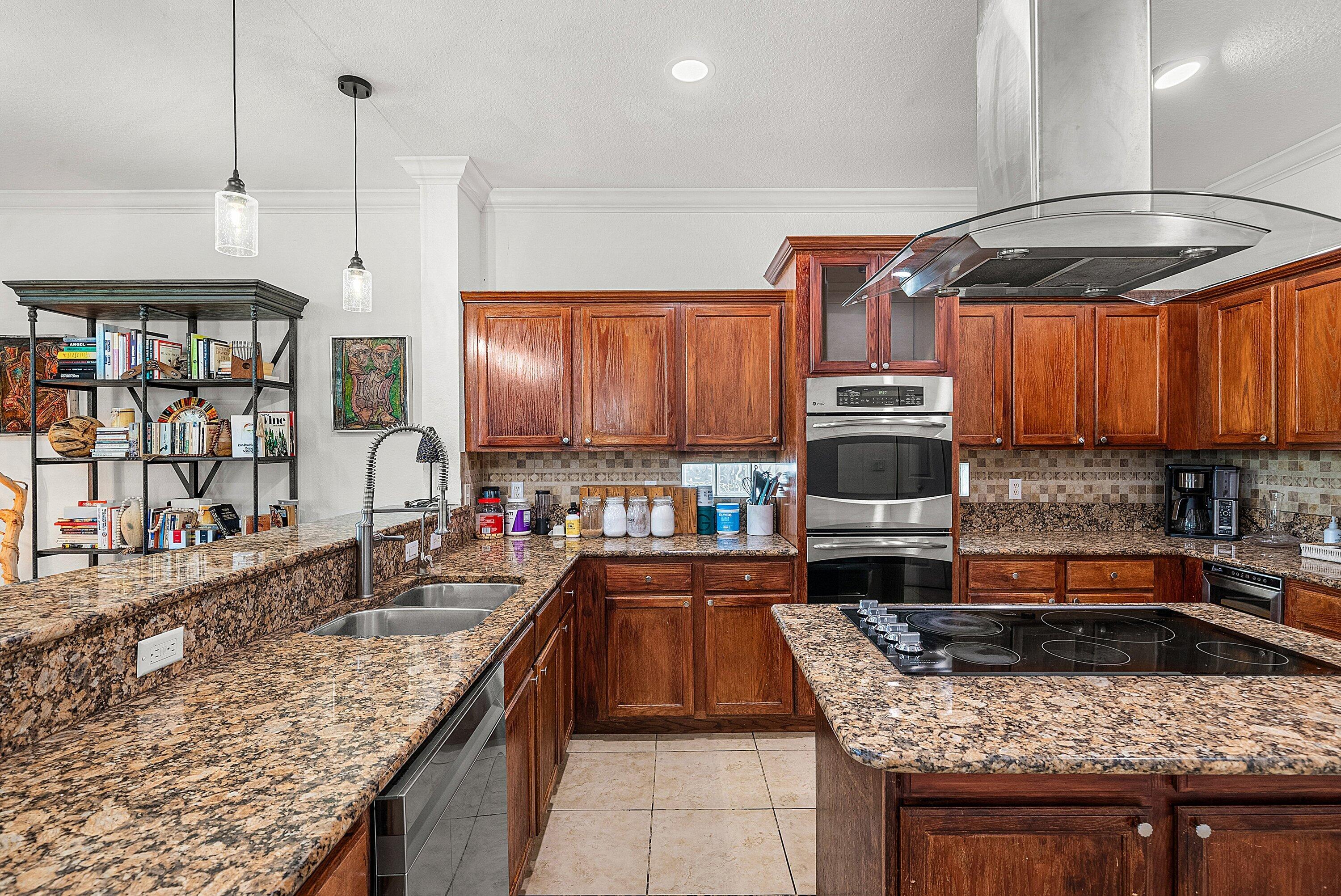 1509 Sage Wood Court Riviera Beach, FL 33404 - Photo 17 of 59 a kitchen with stainless steel appliances granite countertop a stove a sink and a wooden cabinets