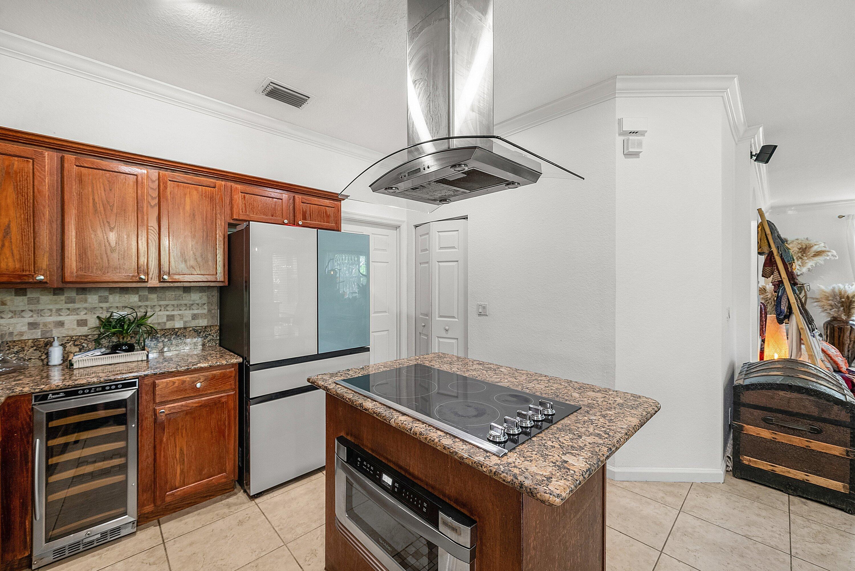 1509 Sage Wood Court Riviera Beach, FL 33404 - Photo 18 of 59 a kitchen with stainless steel appliances a stove a refrigerator and cabinets
