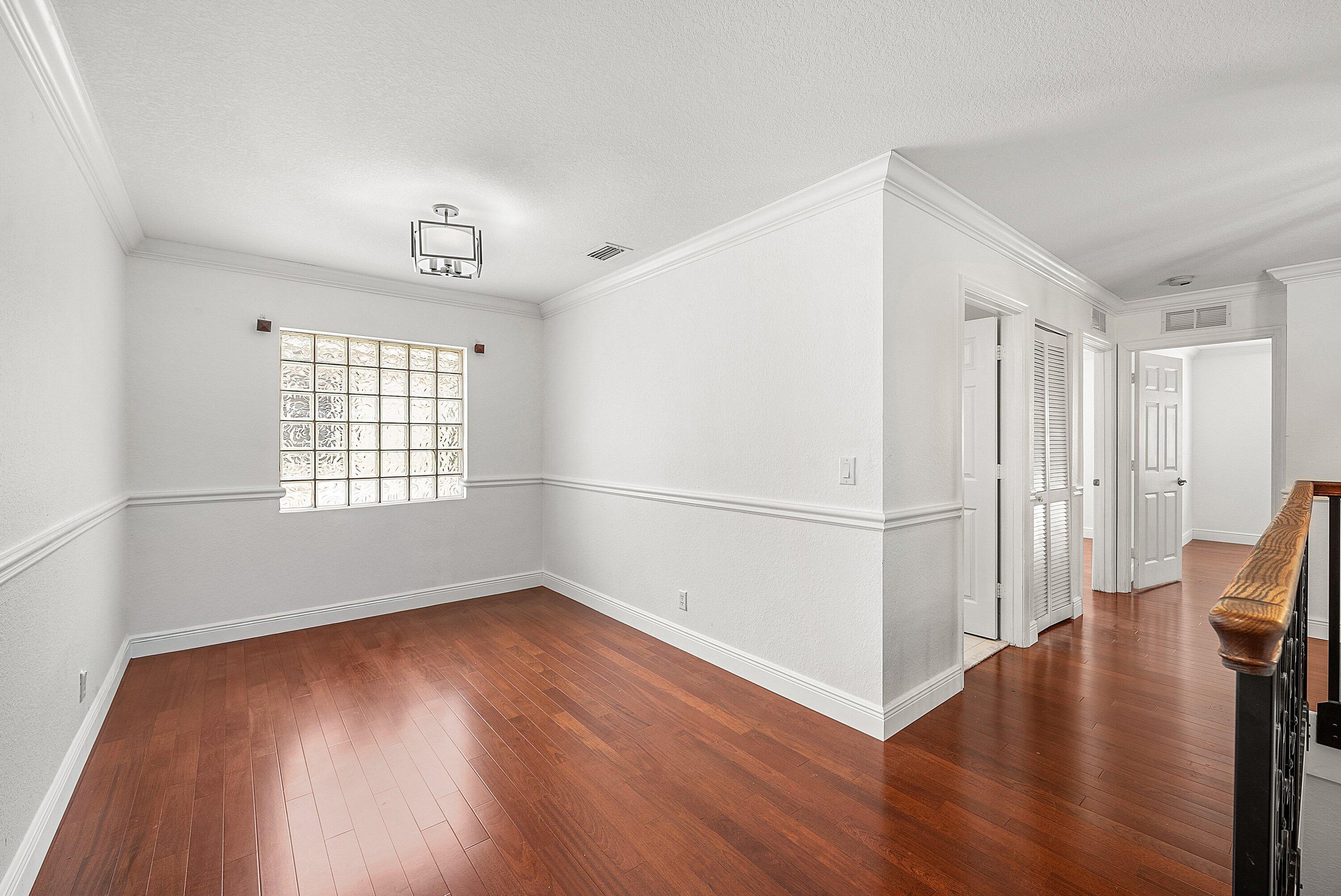 1509 Sage Wood Court Riviera Beach, FL 33404 - Photo 22 of 59 an empty room with wooden floor and windows