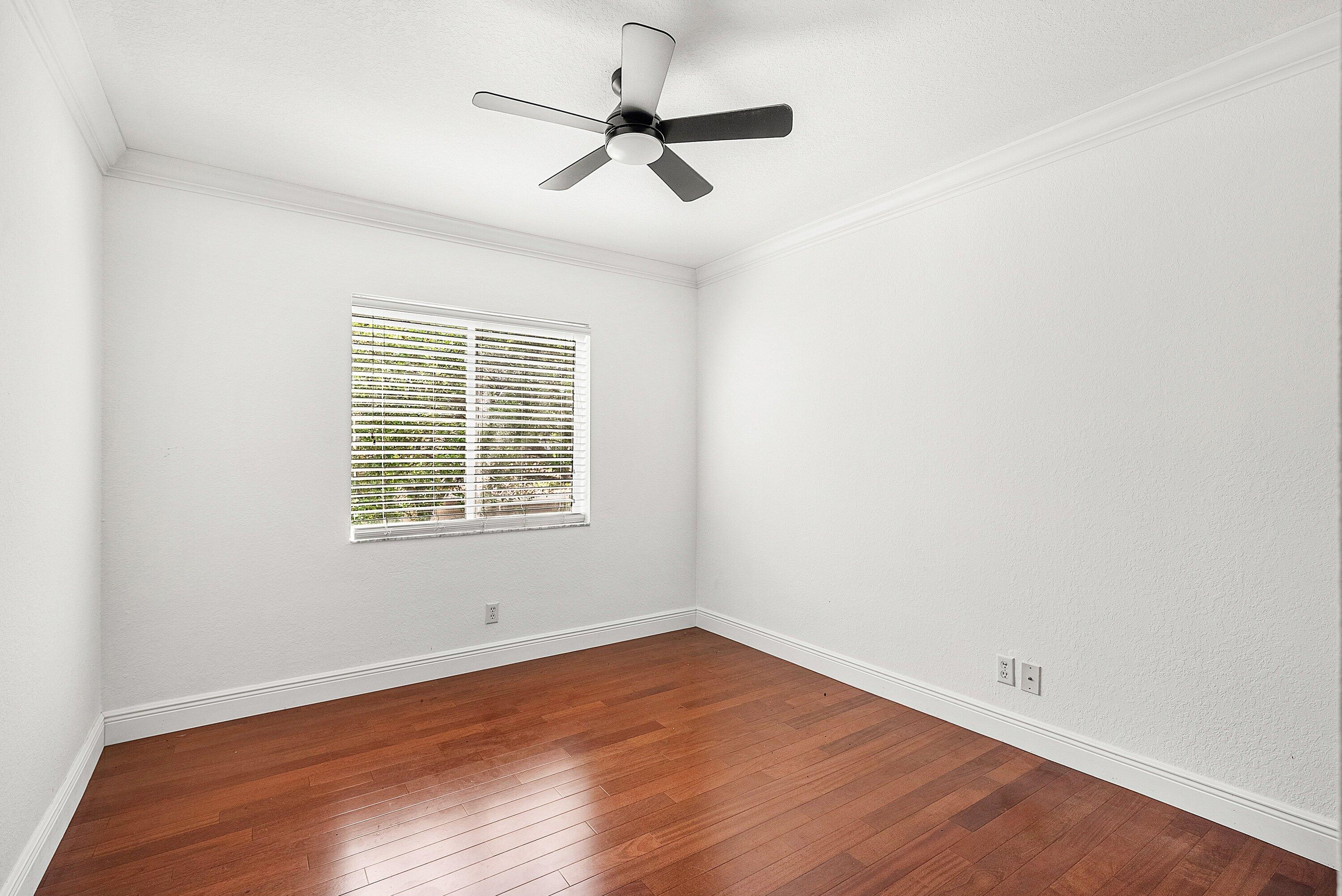 1509 Sage Wood Court Riviera Beach, FL 33404 - Photo 27 of 59 an empty room with wooden floor ceiling fan and window