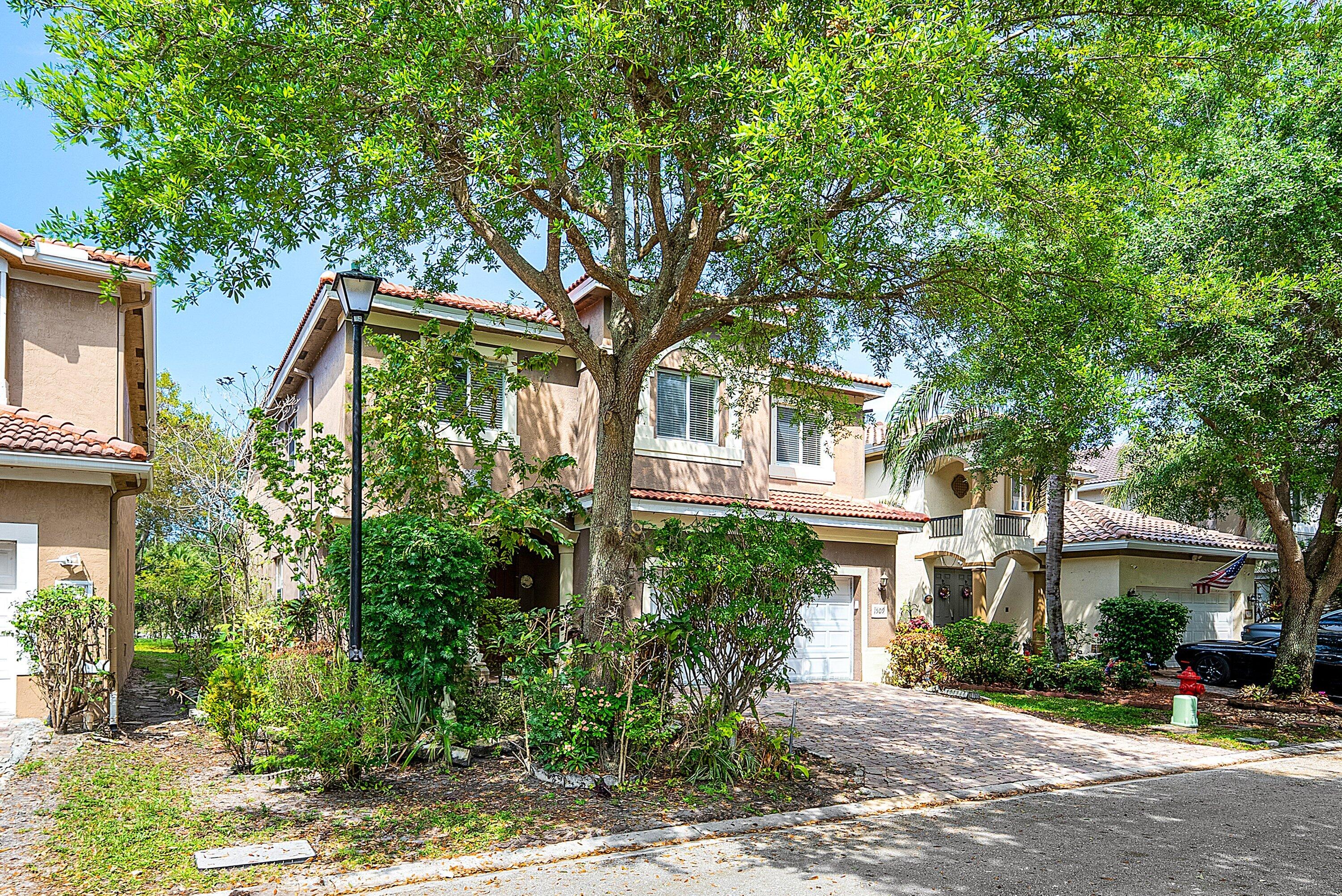 1509 Sage Wood Court Riviera Beach, FL 33404 - Photo 3 of 59 a front view of a house with a tree