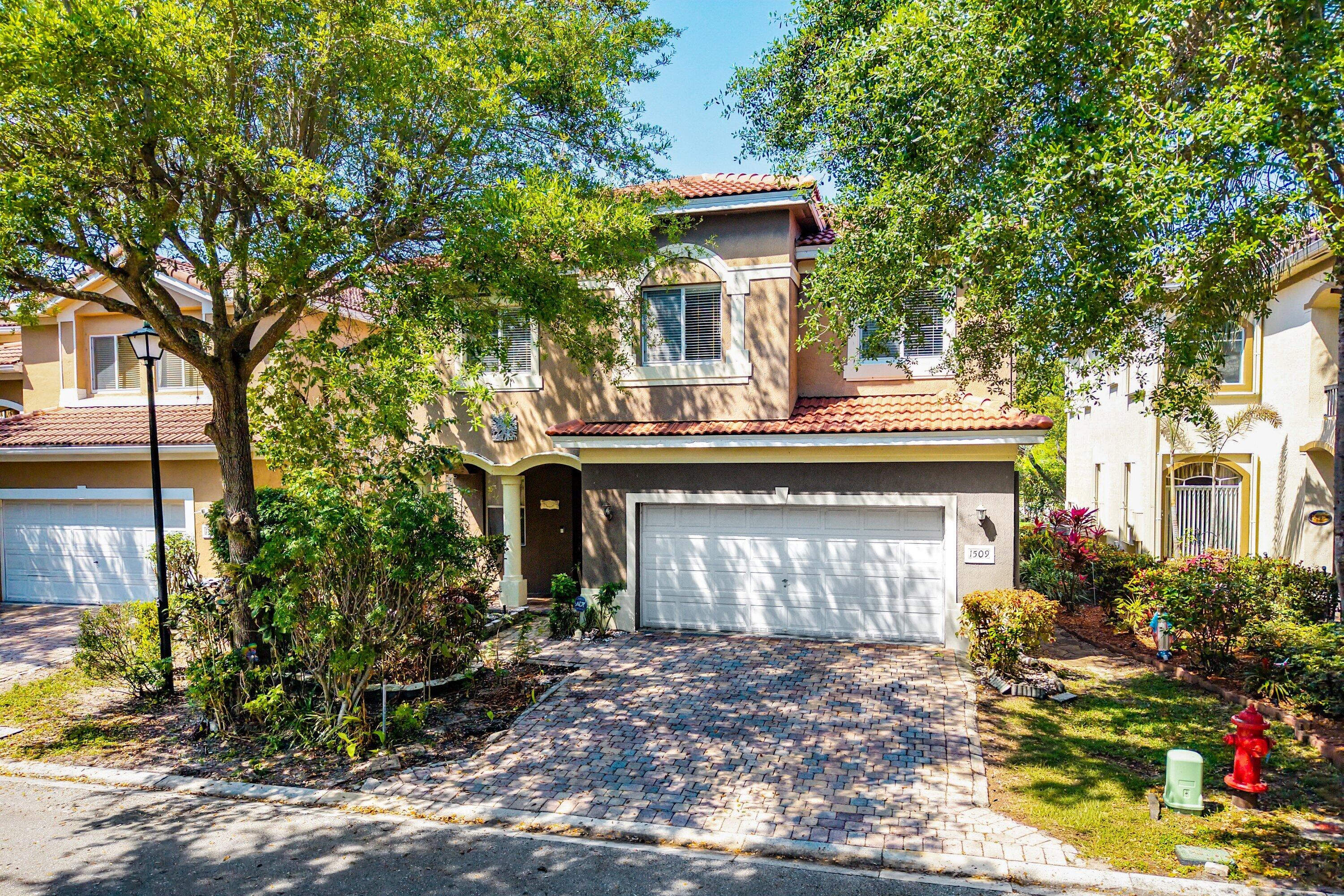 1509 Sage Wood Court Riviera Beach, FL 33404 - Photo 45 of 59 a front view of a house with garden