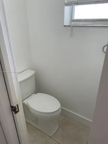 a white toilet sitting next to a window