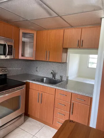a kitchen with granite countertop cabinets stainless steel appliances and sink