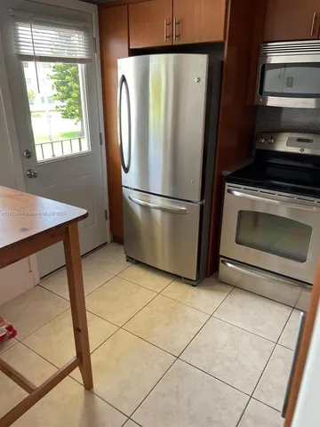 a kitchen with a stove top oven and refrigerator