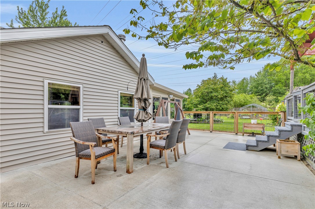 8704 Columbia Road Olmsted Falls, OH 44138 - Photo 27 of 34 Concrete patio featuring a dining area, a tiered staircase, and a wood-slat fence