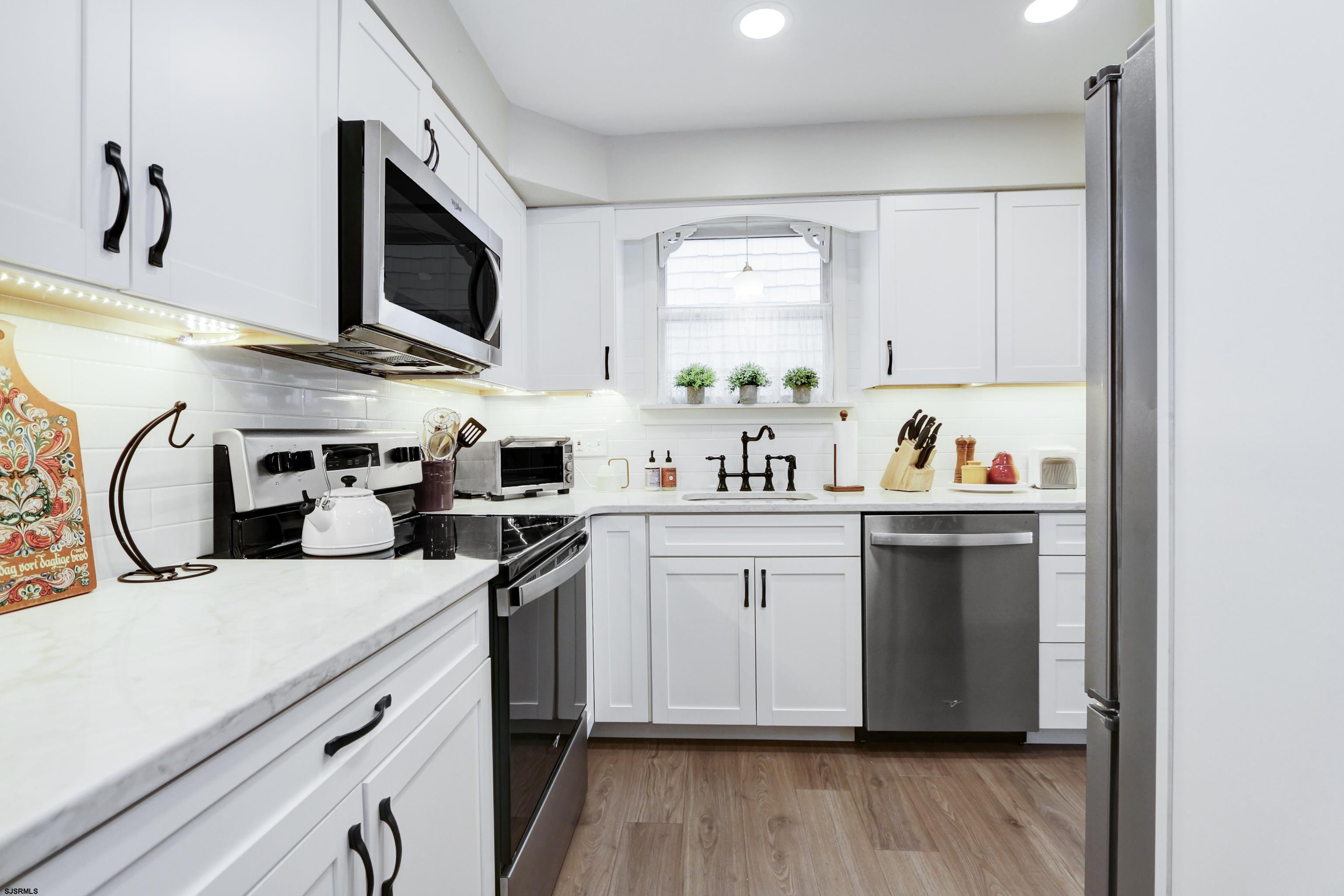 313 West Brigantine Avenue, Unit 4 Brigantine, NJ 08203 - Photo 11 of 38 a kitchen with stainless steel appliances a sink a stove a microwave and cabinets