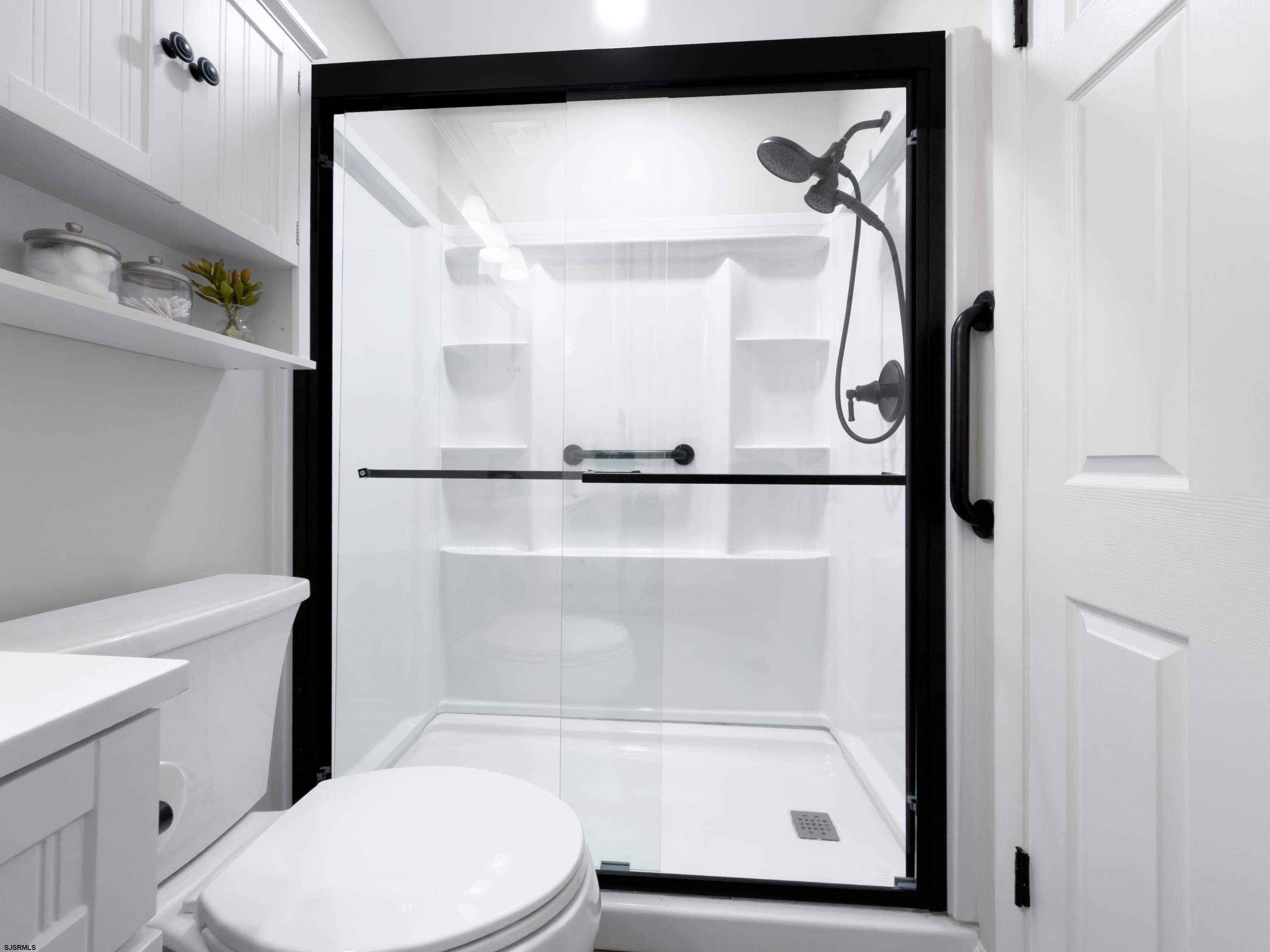 313 West Brigantine Avenue, Unit 4 Brigantine, NJ 08203 - Photo 16 of 38 a bathroom with a glass shower door and a toilet