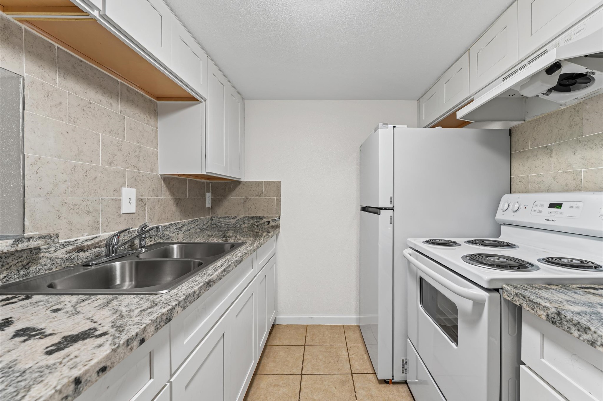 6161 Reims Road, Unit 304 Houston, TX 77036 - Photo 6 of 16 a kitchen that has a sink and a stove