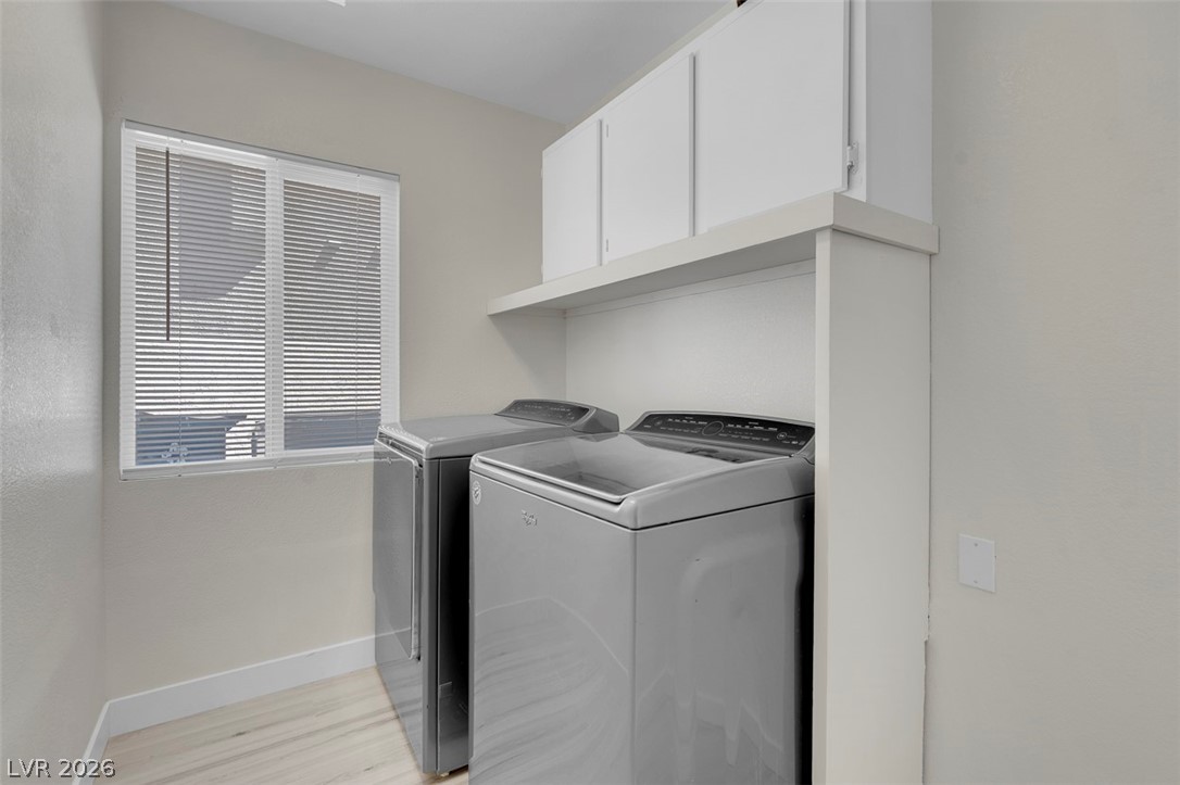 3604 North Campbell Road Las Vegas, NV 89129 - Photo 49 of 54 Laundry area with washer and clothes dryer, baseboards, light wood-style floors, and cabinet space