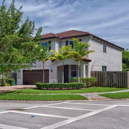 11850 Southwest 250th Terrace Homestead, FL 33032 - Photo 2 of 47 a front view of a house with a garden