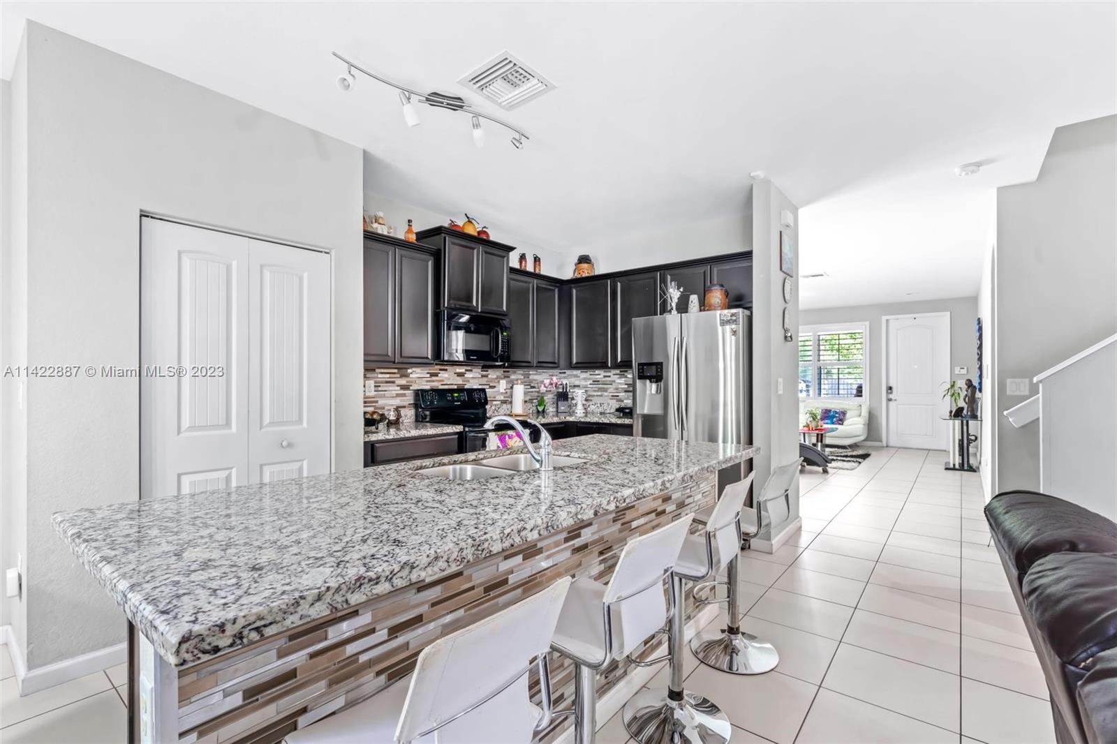 11850 Southwest 250th Terrace Homestead, FL 33032 - Photo 23 of 47 a large kitchen with granite countertop a counter space a sink stainless steel appliances and cabinets