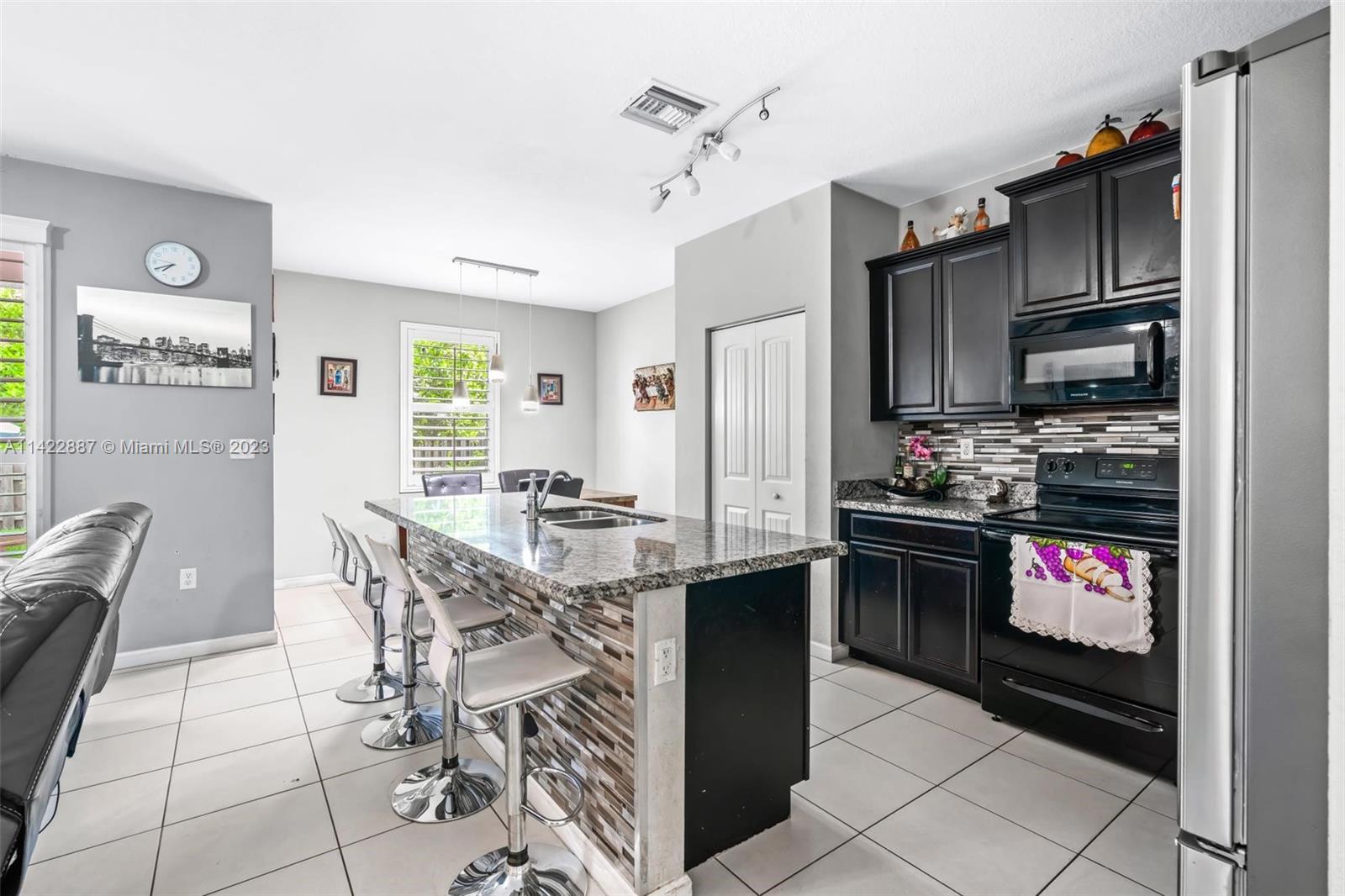 11850 Southwest 250th Terrace Homestead, FL 33032 - Photo 24 of 47 a kitchen with granite countertop a stove cabinets and refrigerator