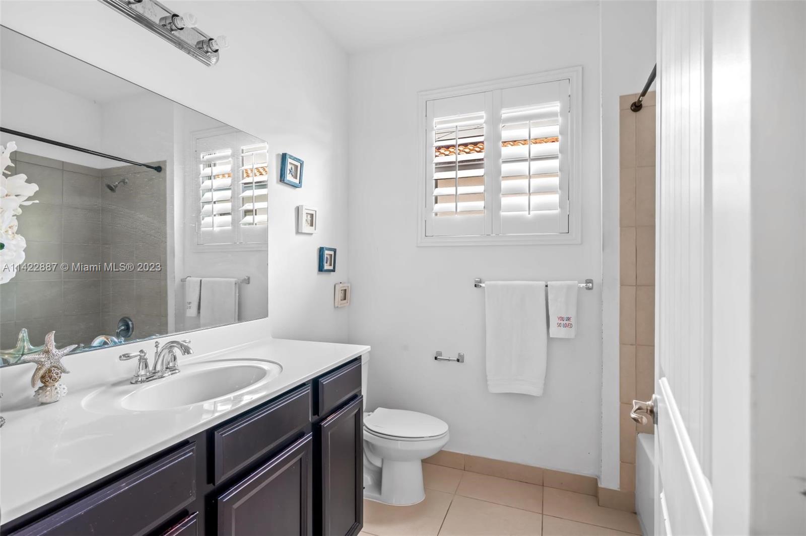 11850 Southwest 250th Terrace Homestead, FL 33032 - Photo 39 of 47 a bathroom with a granite countertop sink toilet a large mirror a shower and a window