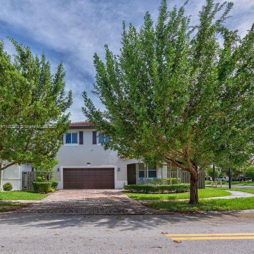 11850 Southwest 250th Terrace Homestead, FL 33032 - Photo 5 of 47 a front view of a house with a yard and garage