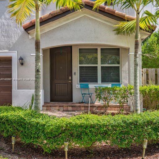 11850 Southwest 250th Terrace Homestead, FL 33032 - Photo 6 of 47 front view of a house with a large window and potted plants
