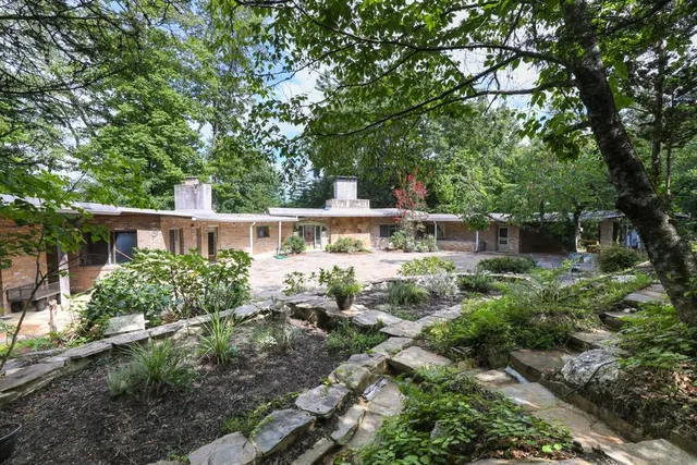 a view of a patio with table and chairs potted plants and large tree