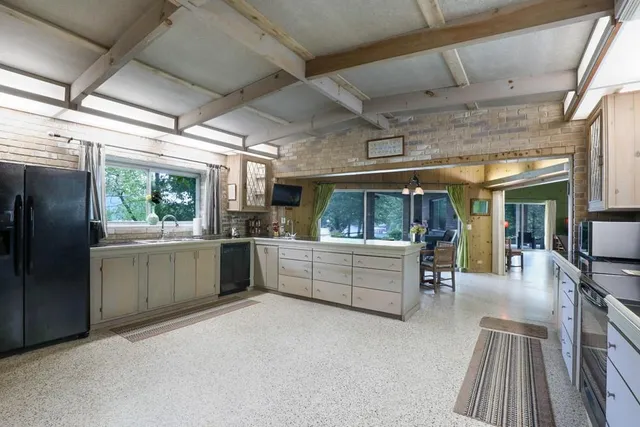 a view of a house with couches chair and potted plants