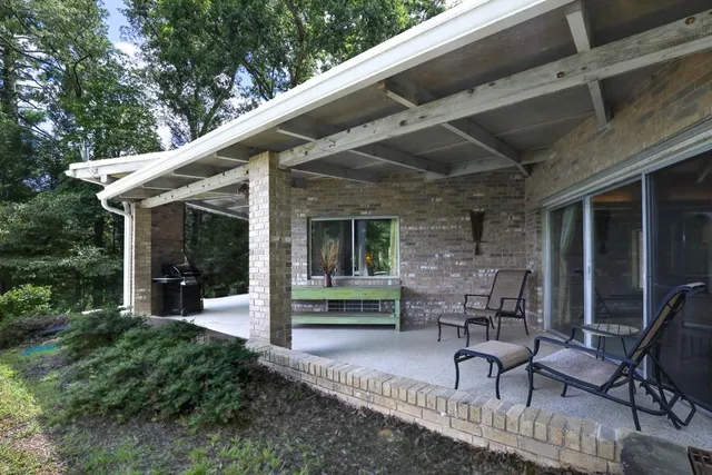 a view of a patio with chairs and a small yard