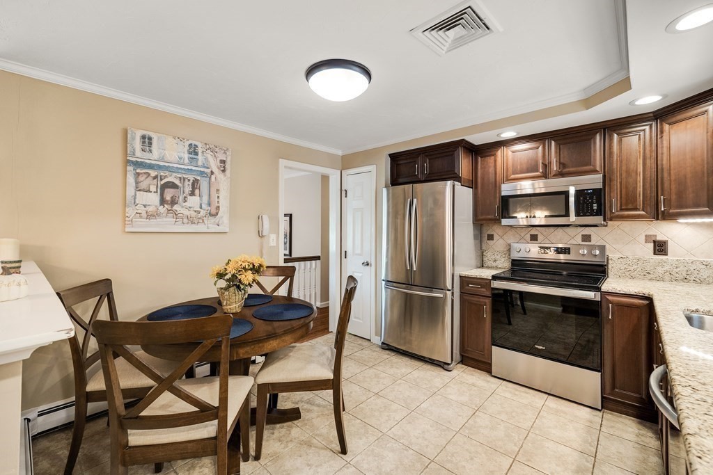 27 Phyllis Road Raynham, MA 02767 - Photo 12 of 42 a kitchen with stainless steel appliances kitchen island granite countertop a dining table and chairs
