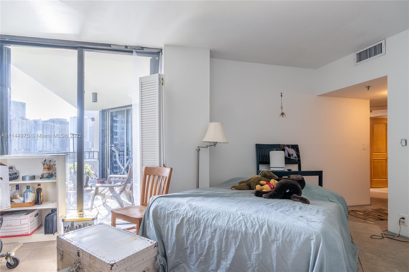 520 Brickell Key Drive, Unit A913 Miami, FL 33131 - Photo 11 of 18 a bedroom with a bed a table and chair