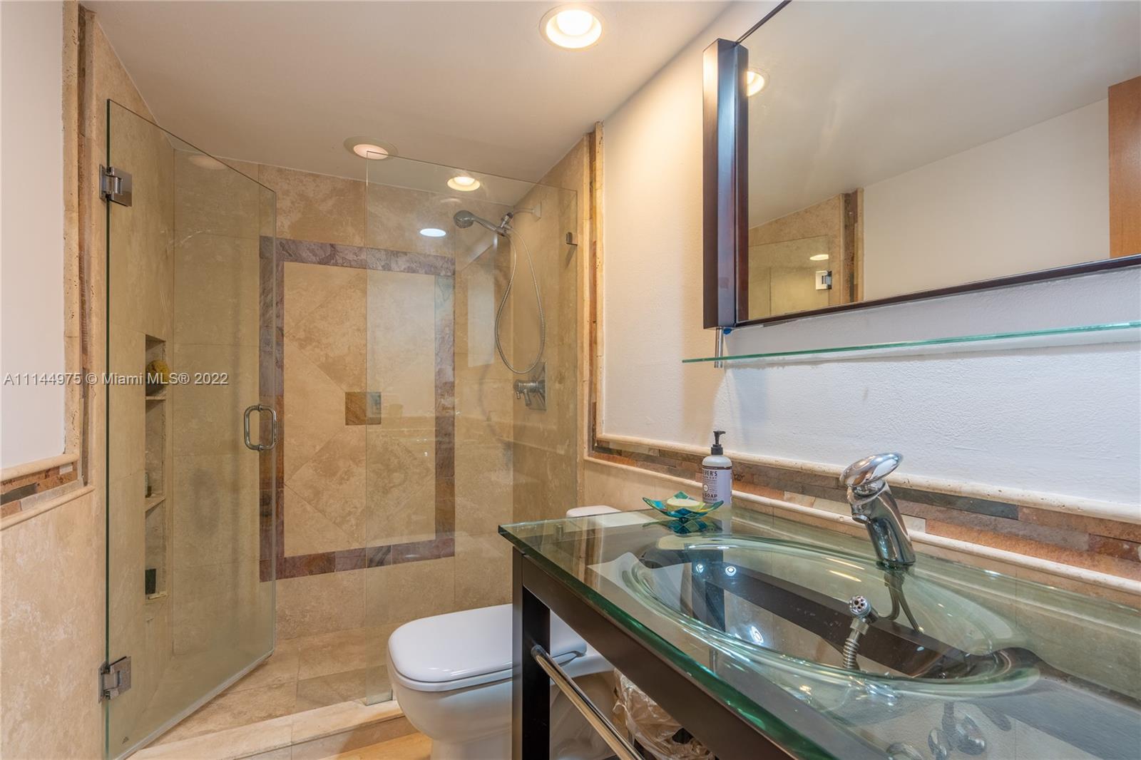 520 Brickell Key Drive, Unit A913 Miami, FL 33131 - Photo 2 of 18 a bathroom with a granite countertop sink a toilet a mirror and shower