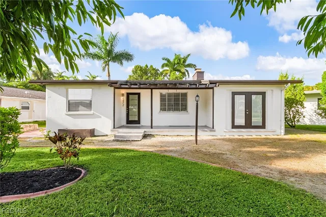 a front view of a house with a garden and patio