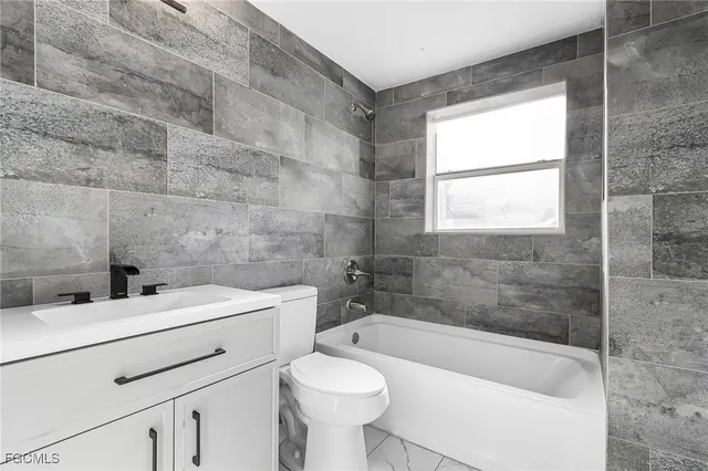 a bathroom with a sink a toilet and bathtub