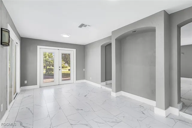 a view of an empty room with window and cabinet