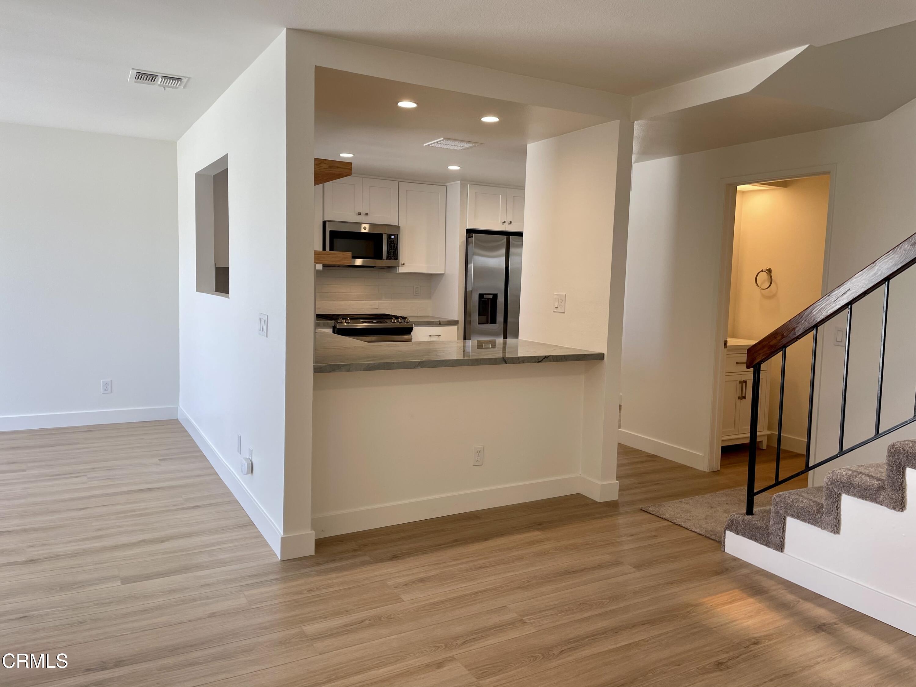 5115 Perkins Road Oxnard, CA 93033 - Photo 5 of 25 a view of a kitchen with wooden floor and electronic appliances
