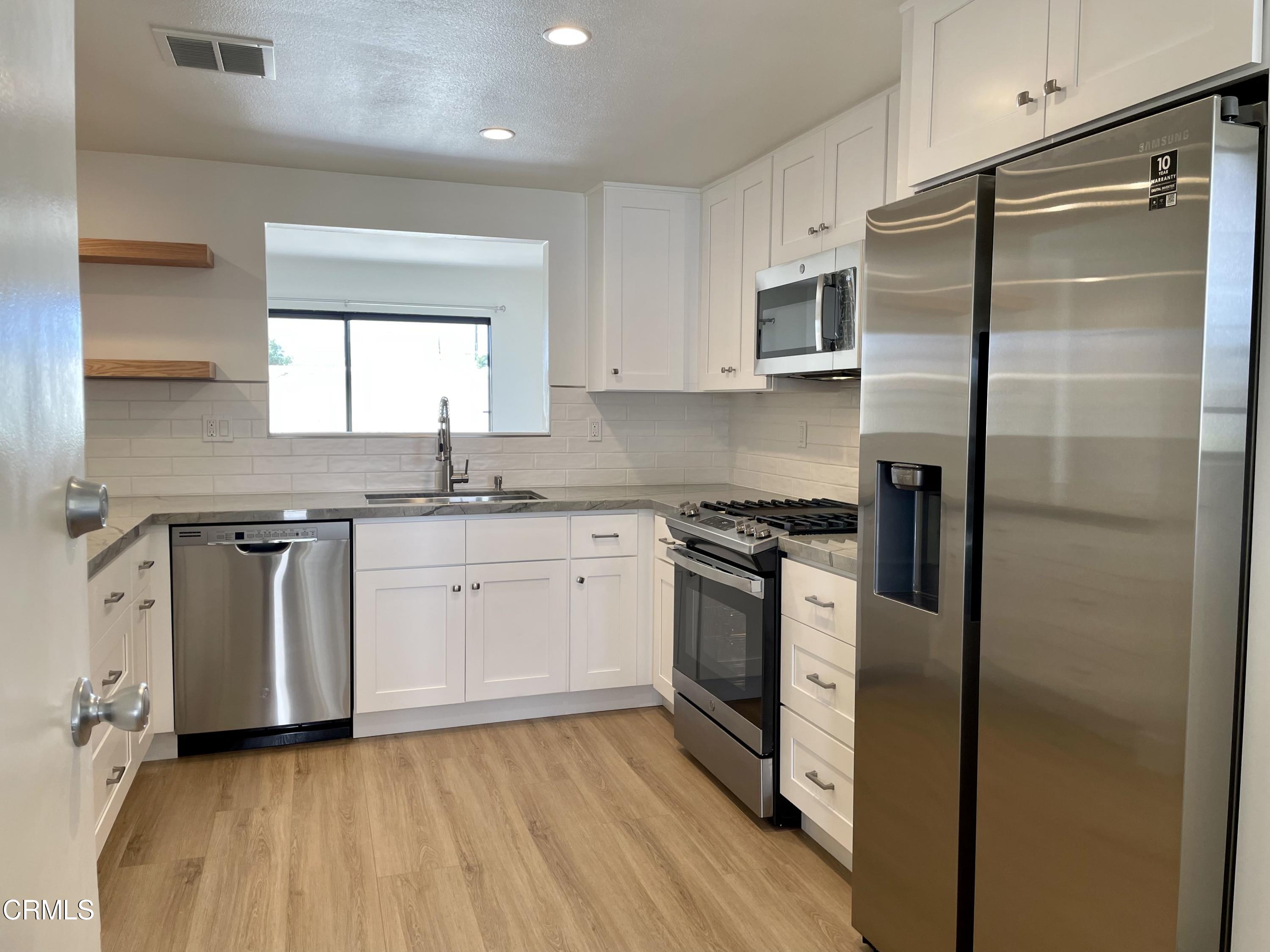 5115 Perkins Road Oxnard, CA 93033 - Photo 7 of 25 a kitchen with stainless steel appliances granite countertop a stove a sink and a refrigerator