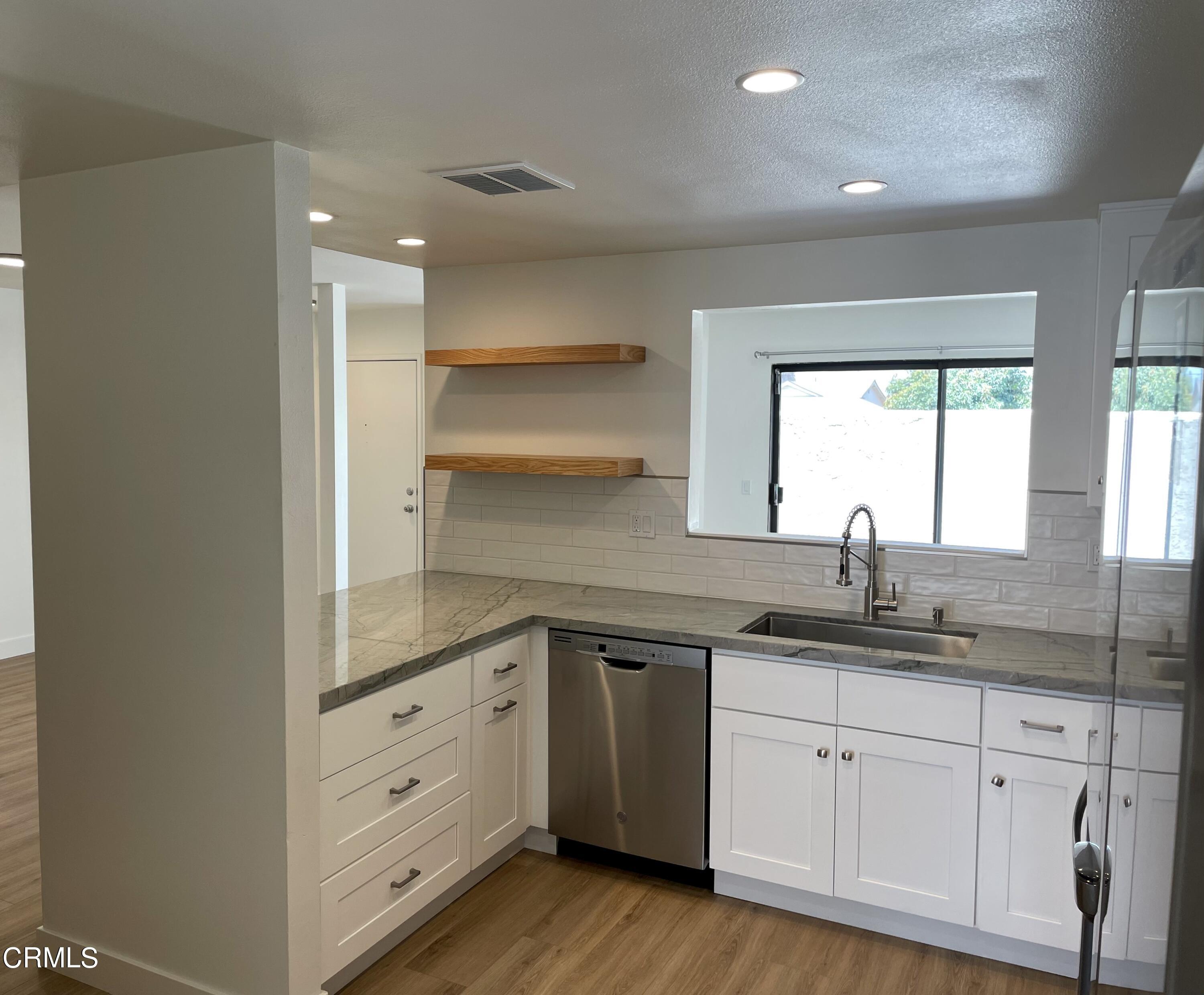 5115 Perkins Road Oxnard, CA 93033 - Photo 9 of 25 a kitchen with granite countertop white cabinets and white appliances