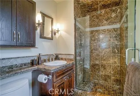 a bathroom with a granite countertop sink a mirror and shower