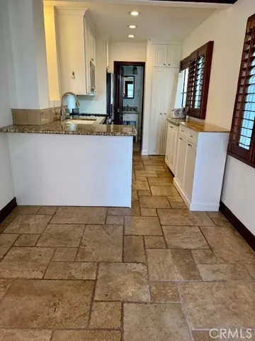 a kitchen with granite countertop a stove a sink and a refrigerator