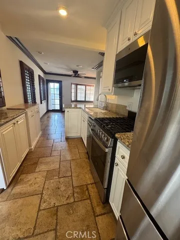 a kitchen with granite countertop a stove a sink and a microwave