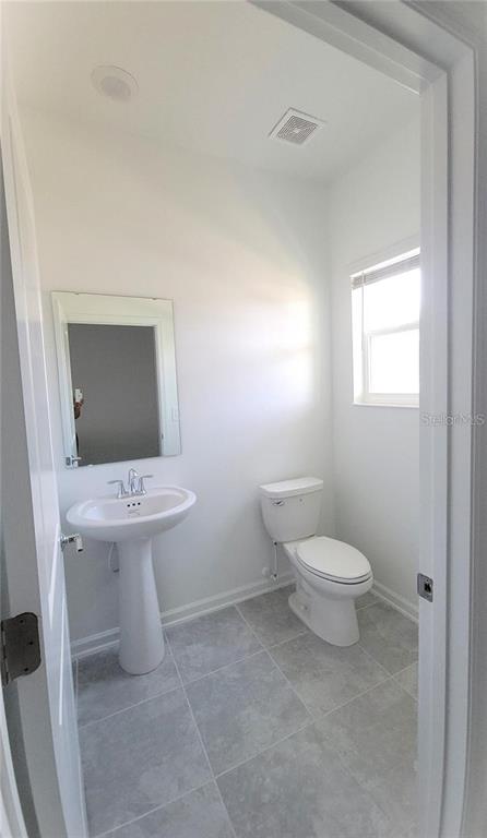 6182 Shavasana Road Clermont, FL 34714 - Photo 12 of 30 a white toilet sitting next to a bathroom sink