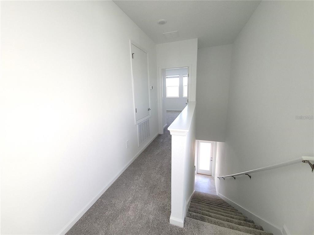 6182 Shavasana Road Clermont, FL 34714 - Photo 16 of 30 a view of a hallway with wooden floor and staircase