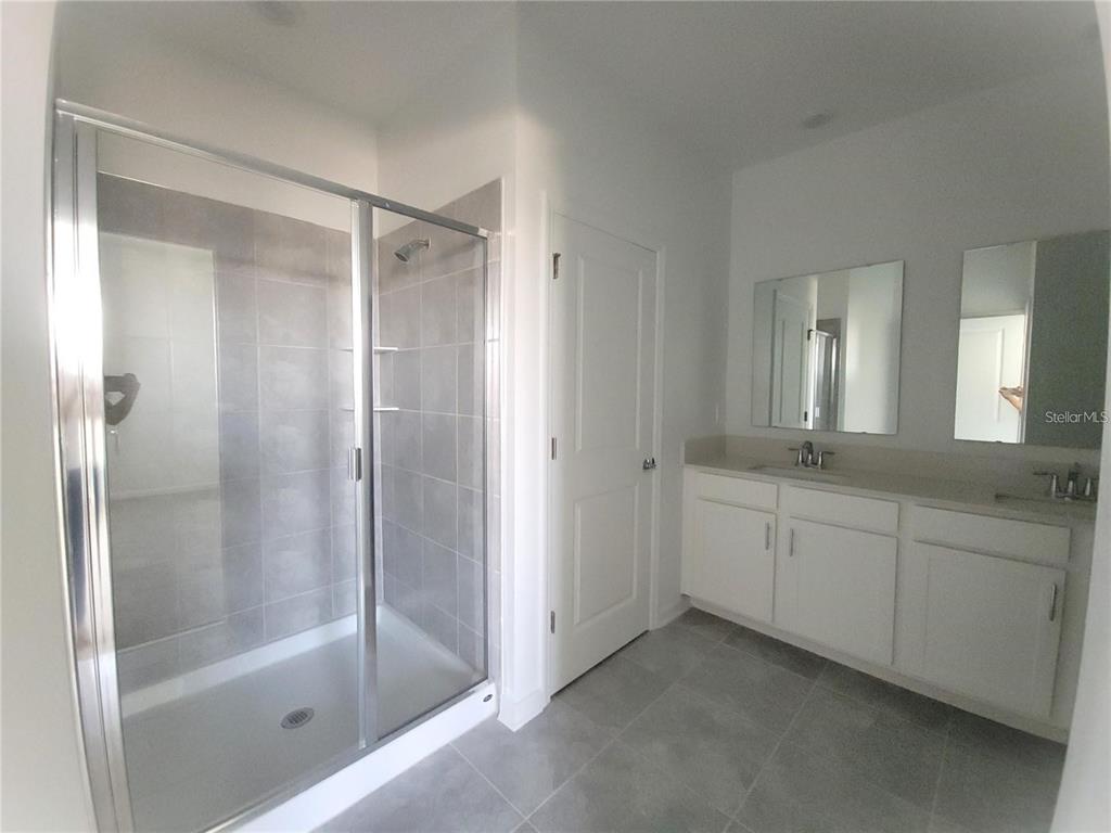 6182 Shavasana Road Clermont, FL 34714 - Photo 20 of 30 a bathroom with a granite countertop sink mirror and a bathtub