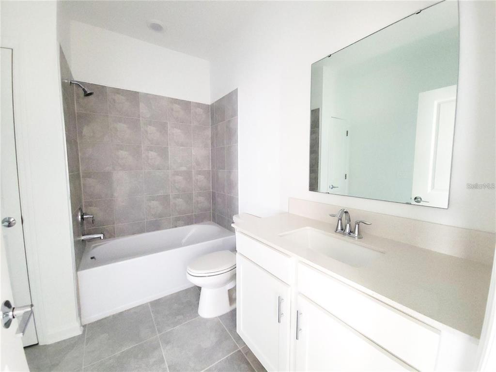 6182 Shavasana Road Clermont, FL 34714 - Photo 21 of 30 a bathroom with a bathtub shower sink mirror and toilet