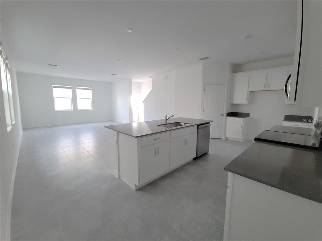 6182 Shavasana Road Clermont, FL 34714 - Photo 6 of 30 a kitchen with stainless steel appliances granite countertop a sink stove and cabinets