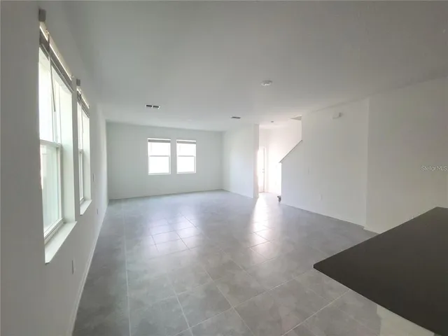 a view of a big room with wooden floor and windows