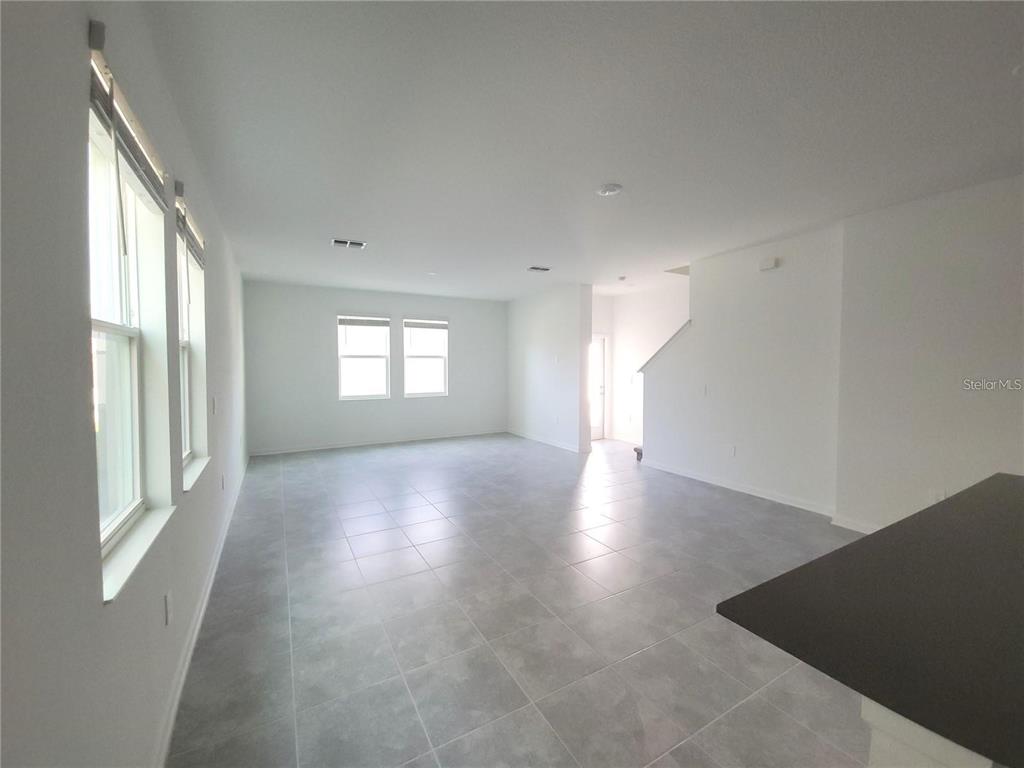 6182 Shavasana Road Clermont, FL 34714 - Photo 8 of 30 a view of a big room with wooden floor and windows