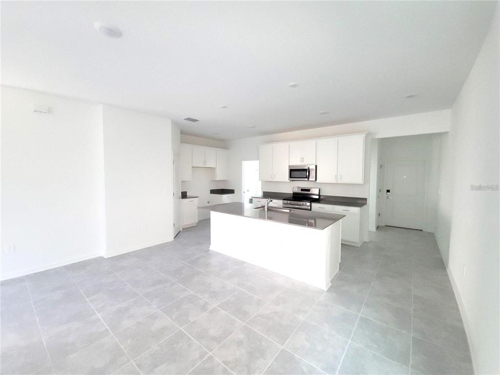 6182 Shavasana Road Clermont, FL 34714 - Photo 9 of 30 a large white kitchen with granite countertop a sink