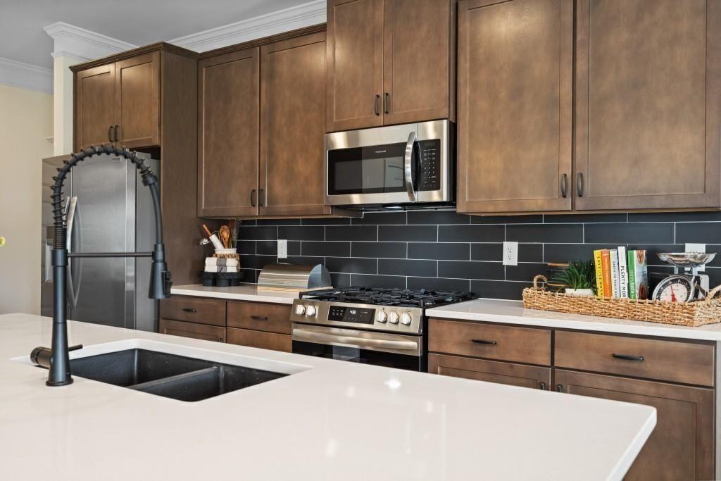 124 Sycamore Lane Calhoun, GA 30701 - Photo 13 of 43 a kitchen with stainless steel appliances a sink a stove a microwave a sink and cabinets
