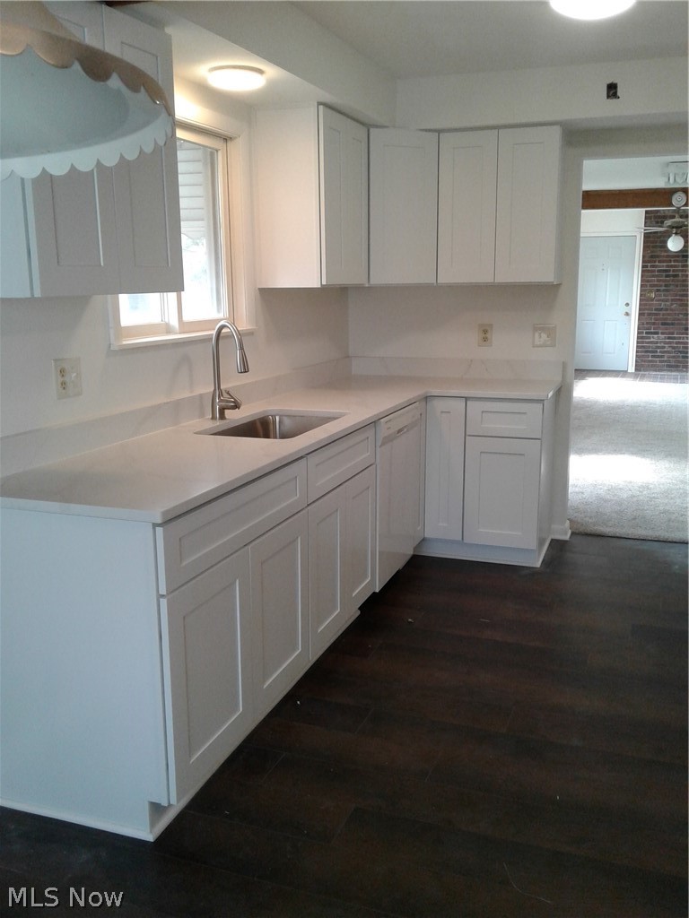 613 Jackson Street Amherst, OH 44001 - Photo 6 of 29 Kitchen with white cabinets, dishwashing machine, light countertops, and dark wood-style flooring