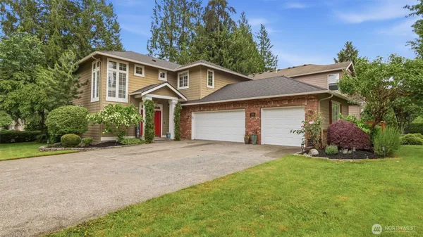 a front view of a house with a garden and yard