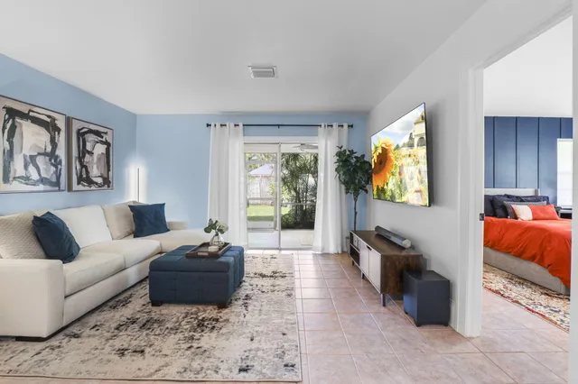 a living room with furniture and a dining table with rug
